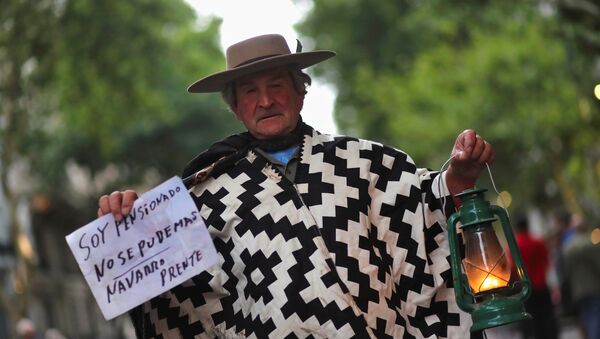 Un hombre sostiene una linterna en una marcha de protesta contra el incremento de tarifas en Buenos Aires - Sputnik Mundo