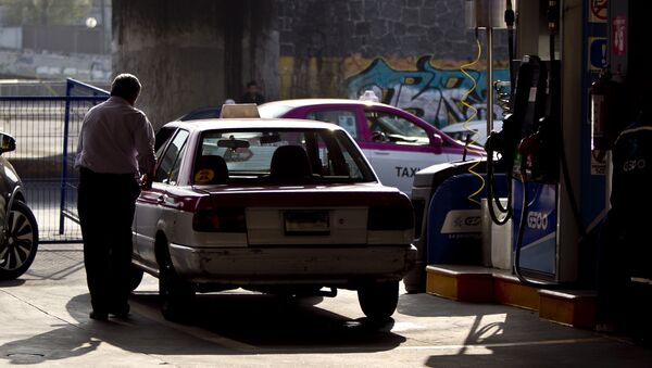 Taxista al terminar de llenar su tanque de gasolina. La mayoría de las filas están llena de taxistas - Sputnik Mundo