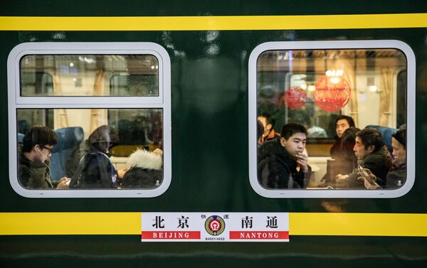 Pasajeros durante la temporada de viajes del Festival de Primavera en la estación ferroviaria de Pekín, China - Sputnik Mundo