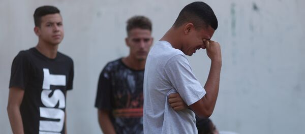 Un jóven llora tras el incendio en un club de fútbol en Río de Janeiro Un jóven llora tras el incendio en un club de fútbol en Río de Janeiro - Sputnik Mundo