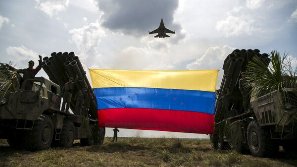 A Russian-made Sukhoi Su-30MKV fighter jet of the Venezuelan Air Force flies over a Venezuelan flag tied to missile launchers, during the Escudo Soberano 2015 (Sovereign Shield 2015) military exercise in San Carlos del Meta in the state of Apure - Sputnik Mundo