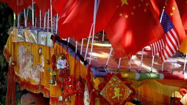 Un conductor mira desde su trishaw decorado con una bandera americana y una china en Pekín - Sputnik Mundo