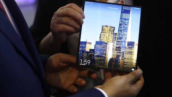Un hombre sostiene un Mate X de Huawei durante el Congreso Mundial de Móviles  - Sputnik Mundo