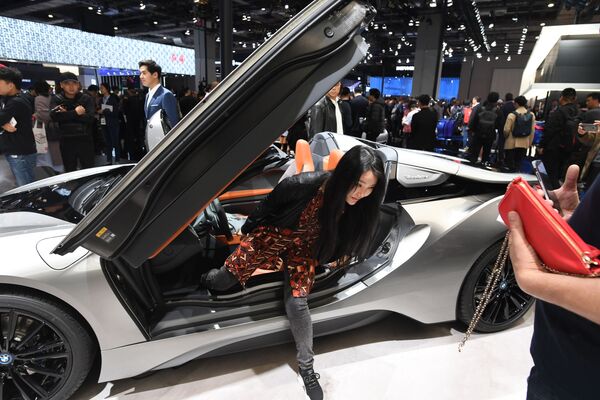 Девушка выходит из автомобиля BMW i8 Roadster на Шанхайском международном автосалоне - Sputnik Mundo