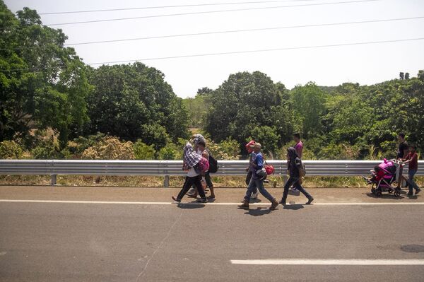 Miembros de la caravana migrante caminan sobre la carretera México 200, rumbo al norte del país, Tapachula, Chiapas, México Miembros de la caravana migrante caminan sobre la carretera México 200, rumbo al norte del país, Tapachula, Chiapas, México - Sputnik Mundo