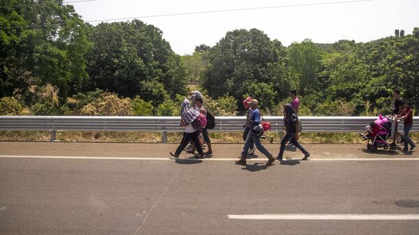 Miembros de la caravana migrante caminan sobre la carretera México 200, rumbo al norte del país, Tapachula, Chiapas, México - Sputnik Mundo
