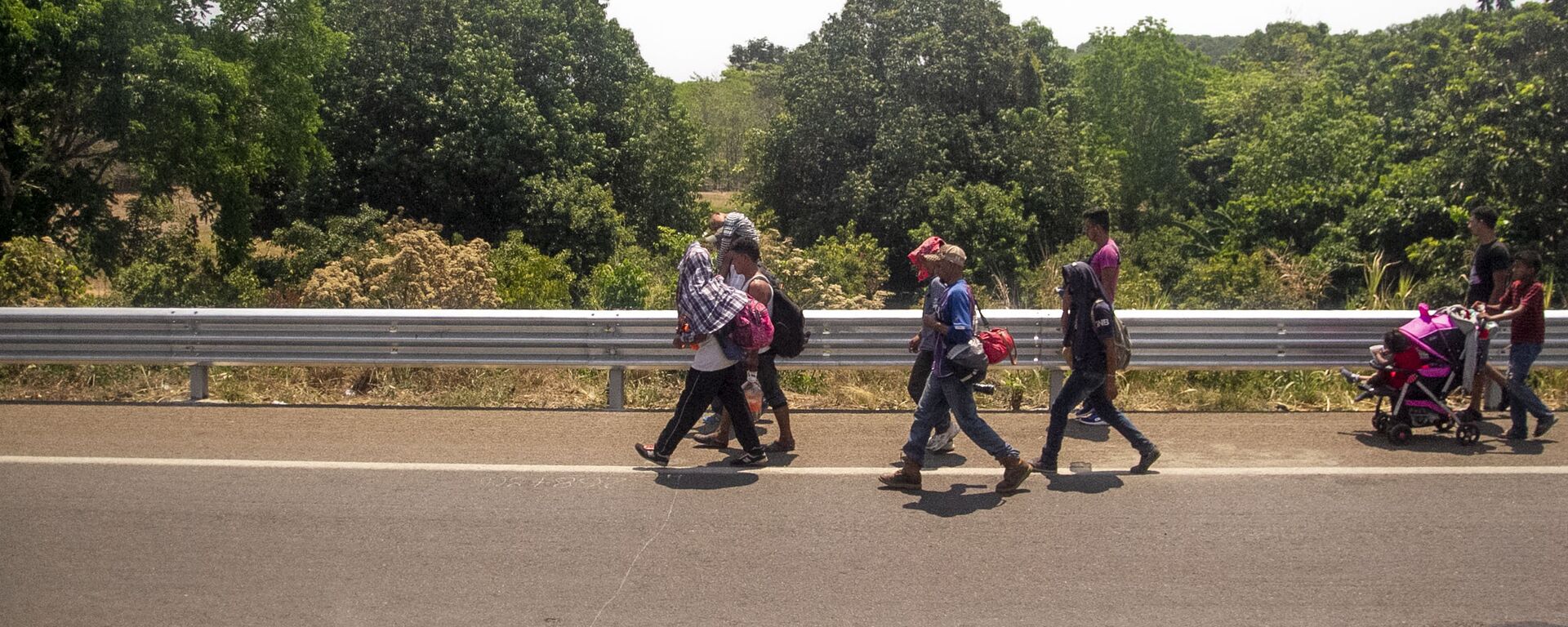 Miembros de la caravana migrante caminan sobre la carretera México 200, rumbo al norte del país, Tapachula, Chiapas, México - Sputnik Mundo, 1920, 01.11.2021