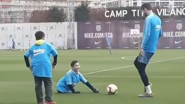 Un sueño hecho realidad: un niño sin piernas juega al fútbol con Piqué y Messi - Sputnik Mundo