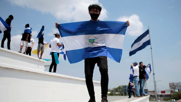 Un hombre con la bandera de Nicaragua - Sputnik Mundo