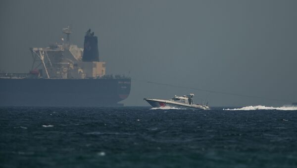 Un barco petrolero y un buque de la guardia costera emiratí - Sputnik Mundo