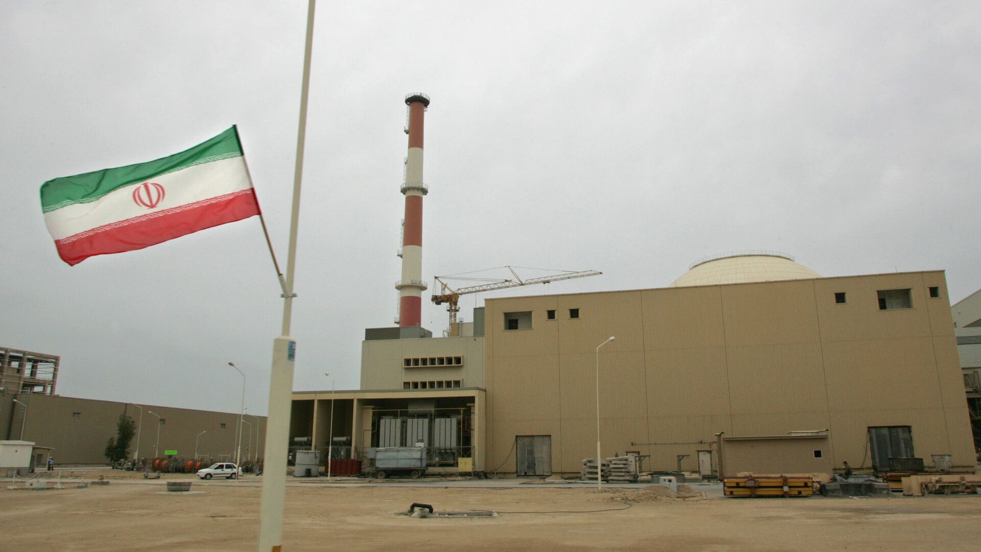 La bandera de Irán junto a la planta nuclear de Bushehr - Sputnik Mundo, 1920, 04.12.2022