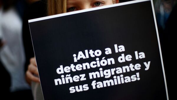 Una niña sostiene un cartel en protesta por la muerte de una pequeña migrante en Ciudad de México - Sputnik Mundo