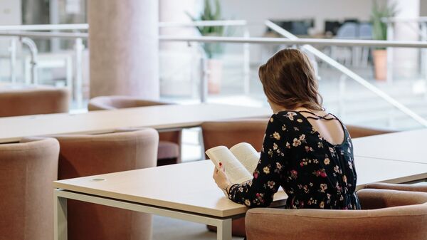 Una joven lee un libro - Sputnik Mundo