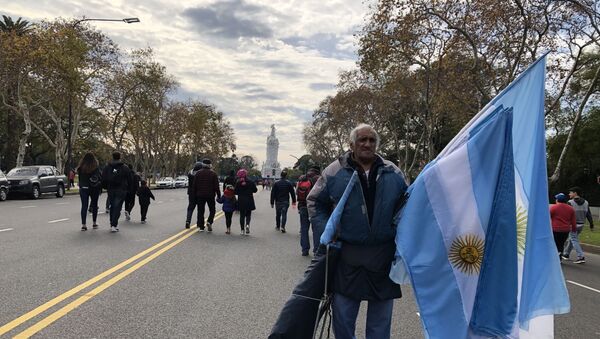 Un hombre vende banderas en la Avenida Libertador en el Día de la Independencia de Argentina - Sputnik Mundo