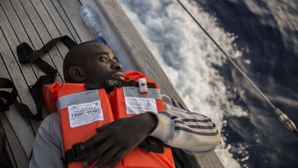 Un migrante a bordo de un barco de la ONG Mediterranea Saving Humans que navega cerca de las costas de la italiana de Lampedusa - Sputnik Mundo