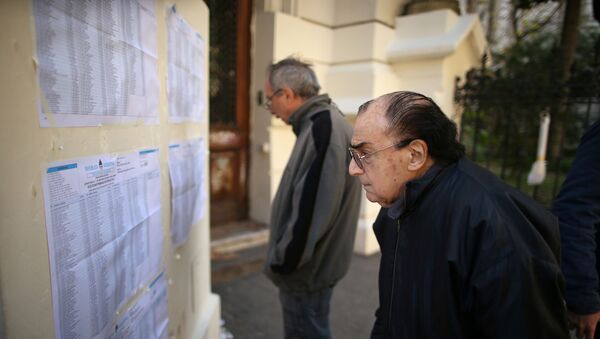Un hombre observa las listas de votantes durante las elecciones primarias en Argentina - Sputnik Mundo