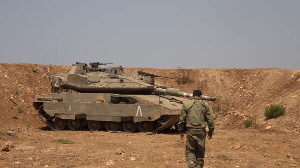 Un soldado israelí camina hacia el tanque en la frontera con Líbano - Sputnik Mundo