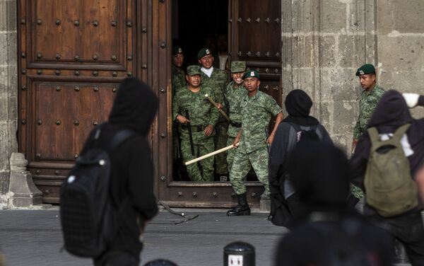 Manifestantes grafitean la puerta del Palacio Nacional, sede de la Presidencia de los Estados Unidos mexicanos durante la marcha a cinco años de la desaparición forzada de los estudiantes.  - Sputnik Mundo