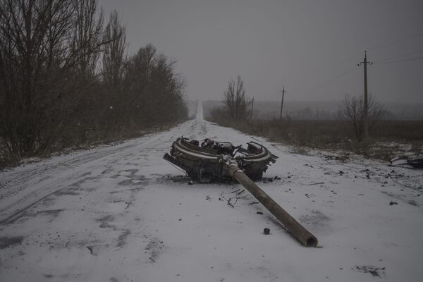 Un fragmento de una torre de tanques en la carretera, consecuencia del bombardeo del pueblo de Kominternovo, región de Donetsk (foto de la serie Zona Gris) - Sputnik Mundo