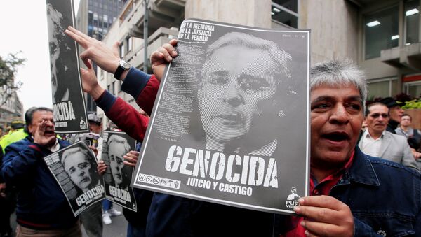 Manifestantes con retratos de Álvaro Uribe - Sputnik Mundo