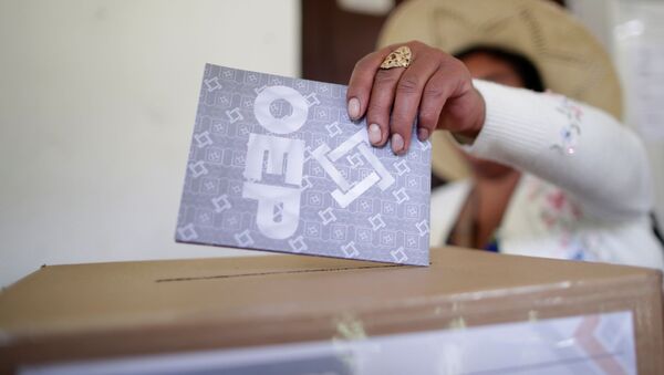 Una persona deposita su voto en las urnas en las elecciones generales en Bolivia - Sputnik Mundo