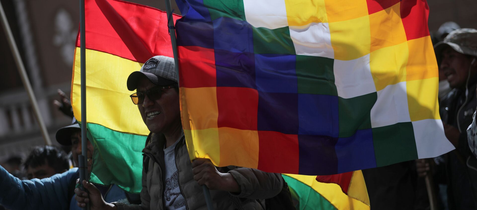 La bandera wiphala y la tradicional de Bolivia alzada por un manifestante durante una marcha en La Paz en apoyo a Evo Morales, noviembre de 2019 - Sputnik Mundo, 1920, 13.11.2019