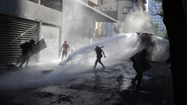 Carabineros dispersando una marcha en Santiago, Chile - Sputnik Mundo