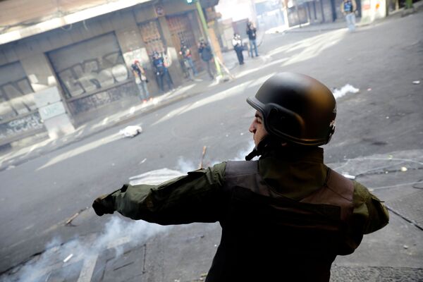 Un miembro de las fuerzas de seguridad lanza una lata de gas lacrimógeno durante los enfrentamientos con los partidarios del expresidente boliviano, Evo Morales, en La Paz (Bolivia). - Sputnik Mundo