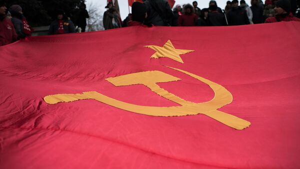 Bandera de la URSS en una marcha dedicada al aniversario de la Revolución de Octubre (2016) - Sputnik Mundo