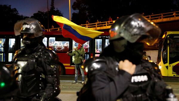 Policías colombianos custodian una calle de Bogotá frente a manifestantes - Sputnik Mundo