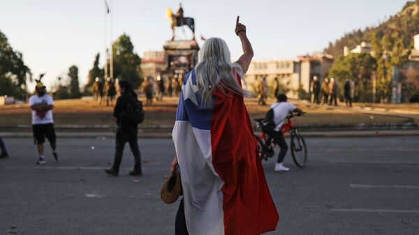 Un manifestante con la bandera de Chile durante las protestas - Sputnik Mundo