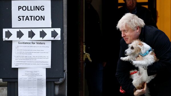 El primer ministro del reino Unido, Boris Johnson, sale de un colegio electoral con su perro Dilyn - Sputnik Mundo