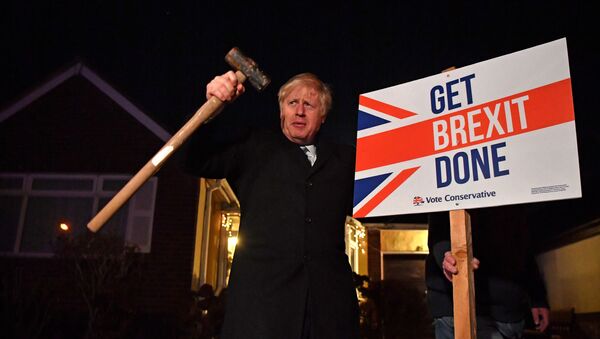 El primer ministro británico, Boris Johnson con un letrero del Brexit - Sputnik Mundo