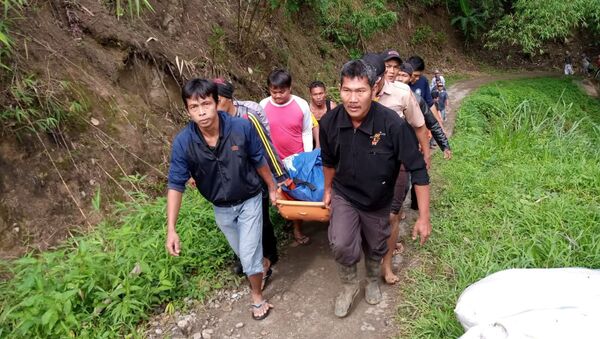 Rescatistas indonesios con un cuerpo tras el accidente de autobús - Sputnik Mundo