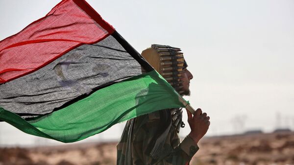 Un hombre con la bandera de Libia - Sputnik Mundo
