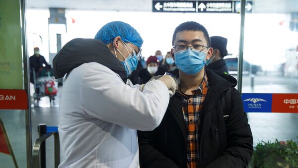Un chino durante la revisión para detectar el coronavirus - Sputnik Mundo