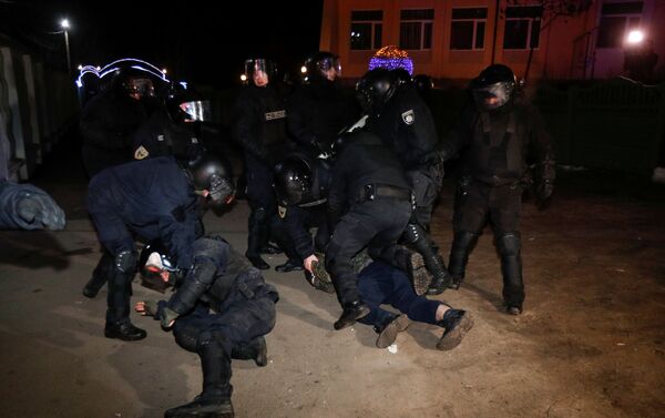 Policías ucranianos detienen a un hombre durante una protesta contra la llegada de un avión que transportaba a evacuados de China - Sputnik Mundo