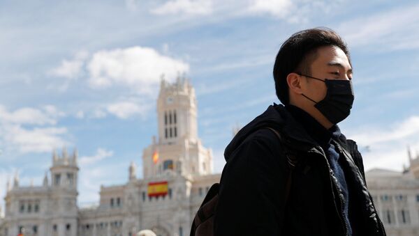 Una persona con mascarilla en Madrid - Sputnik Mundo