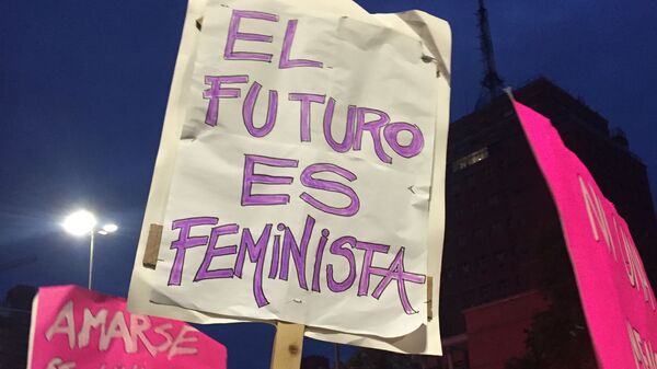 Una mujer sosteniendo una pancarta durante la marcha del 8M en Montevideo, Uruguay - Sputnik Mundo