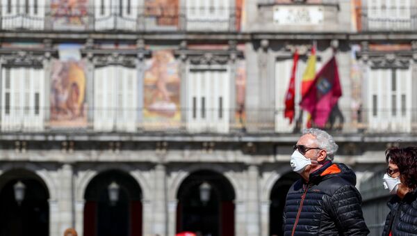 Dos personas con mascarillas en la Plaza Mayor de Madrid - Sputnik Mundo
