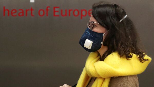 Una mujer con mascarillas en Bruselas - Sputnik Mundo
