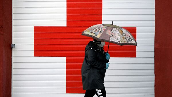 Una persona cerca de la oficina de la Cruz Roja en Oviedo, España - Sputnik Mundo