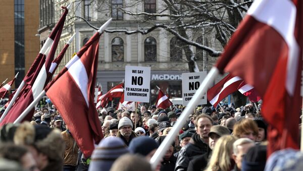 La gente con las banderas de Letonia para conmemorar a los veteranos de la Legión Letona del cuerpo armado de Waffen-SS - Sputnik Mundo