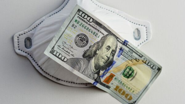 Una mascarilla junto a un billete de 100 dólares. Imagen referencial - Sputnik Mundo