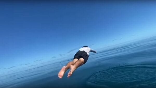 Un pescador se lanza al agua por su caña de pescar - Sputnik Mundo
