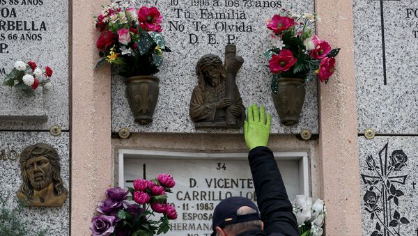 Un hombre cerca de la tumba de sus padres tras la muerte de su madre del coronavirus en España - Sputnik Mundo