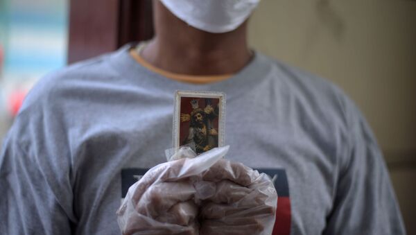 Una persona con una imagen de Jesucristo en Ecuador - Sputnik Mundo