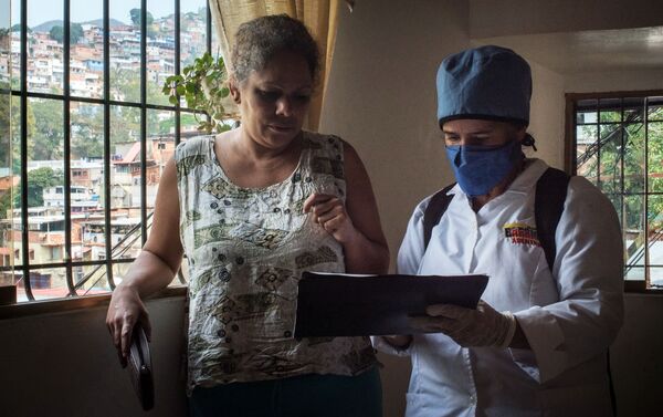 Медицинский работник во время обхода жителей для выявления случаев заболевания коронавирусом в фавелах Каракаса - Sputnik Mundo