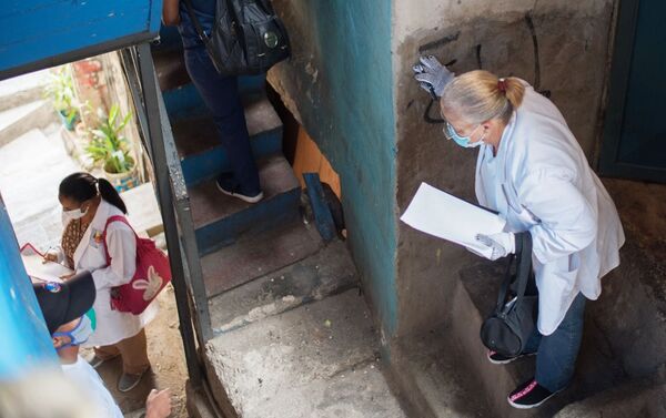 Медицинские работники во время обхода жителей для выявления случаев заболевания коронавирусом в фавелах Каракаса - Sputnik Mundo