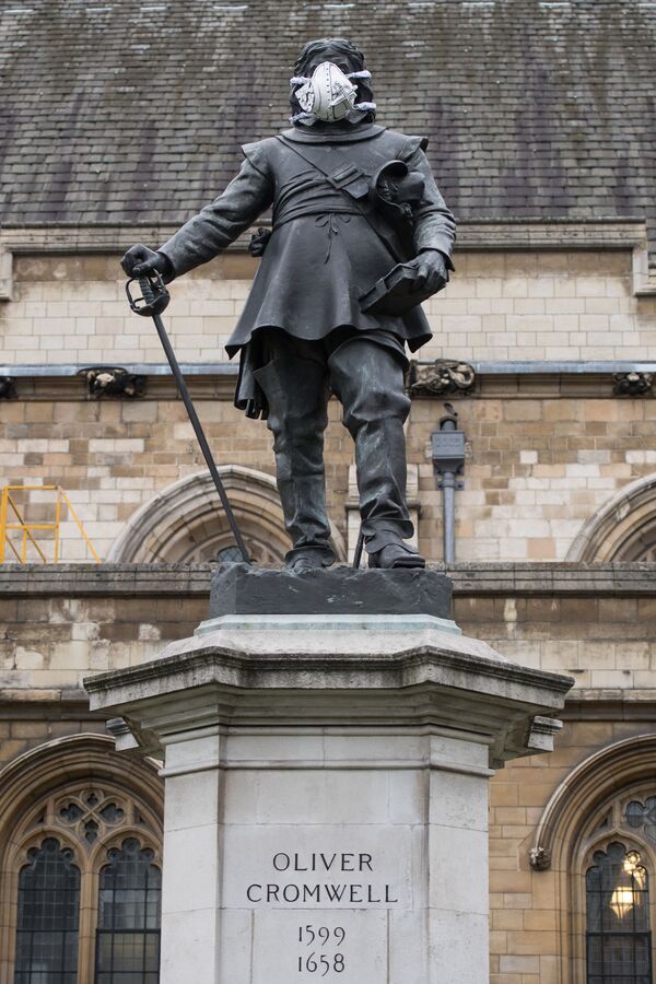 La estatua de Oliver Cromwell, que está justo fuera del Parlamento en el centro de Londres, lleva una mascarilla - Sputnik Mundo